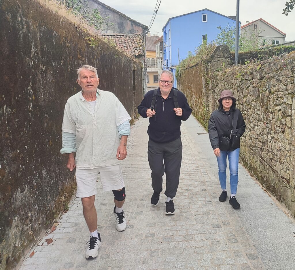 Lars, Per-Olov, and Grace walking along ancient walls in Corcubión