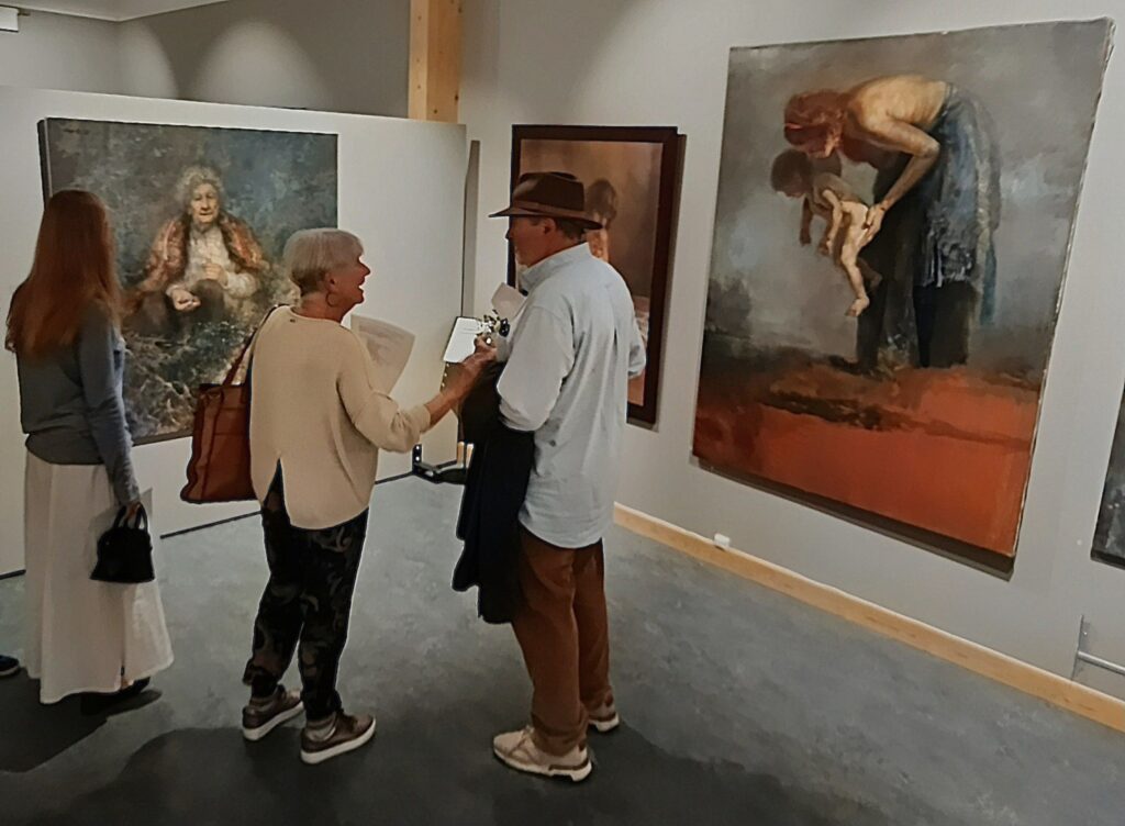 Thorvald sammen med barnebarnet sitt og søsteren Sissel foran portrettet han har malt av sin mor, Miriam